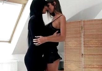 Lesbo cuties embrace and kiss passionately in the living room